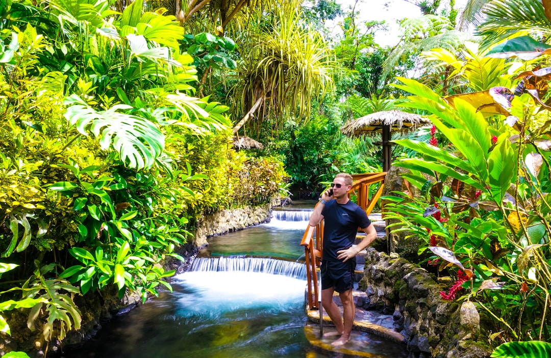 Young Businessman talking on the phone at the Tabacon Resort in Costa Rica.